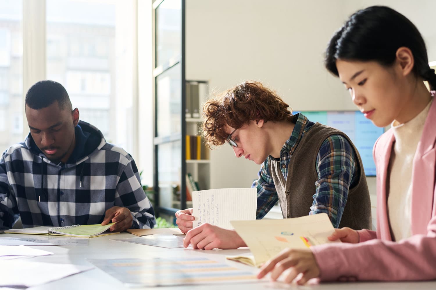 Tres alumnos trabajando en su trabajo fin de máster o TFM
